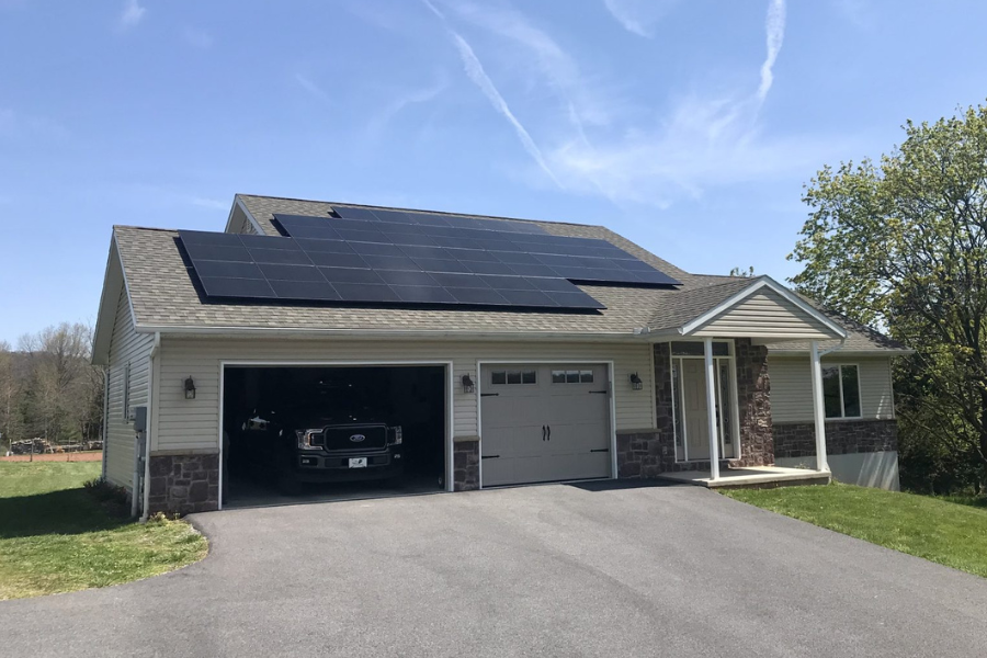 solar panels over two car garage under sky with hardly any clouds