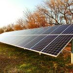 Long rows of solar panels installed along leafless tree-lined property in autumn - Solar system installation by top Solar Installer In Willow Street PA