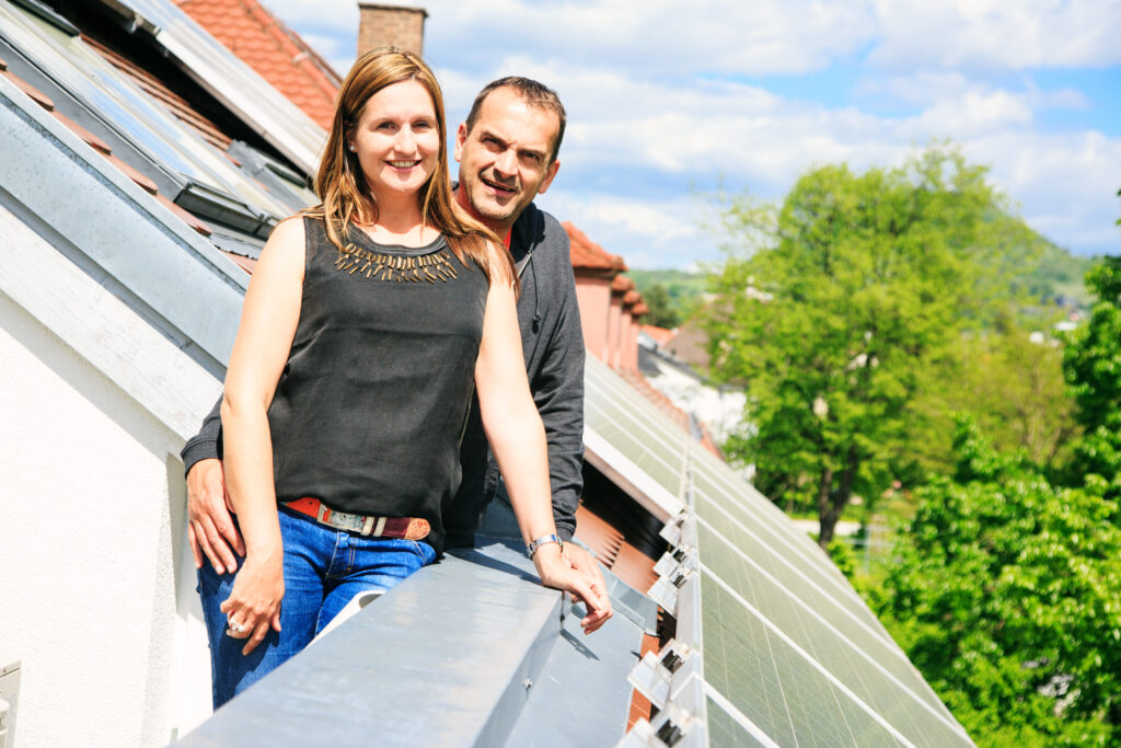 family standing out on roof by their new solar panels
