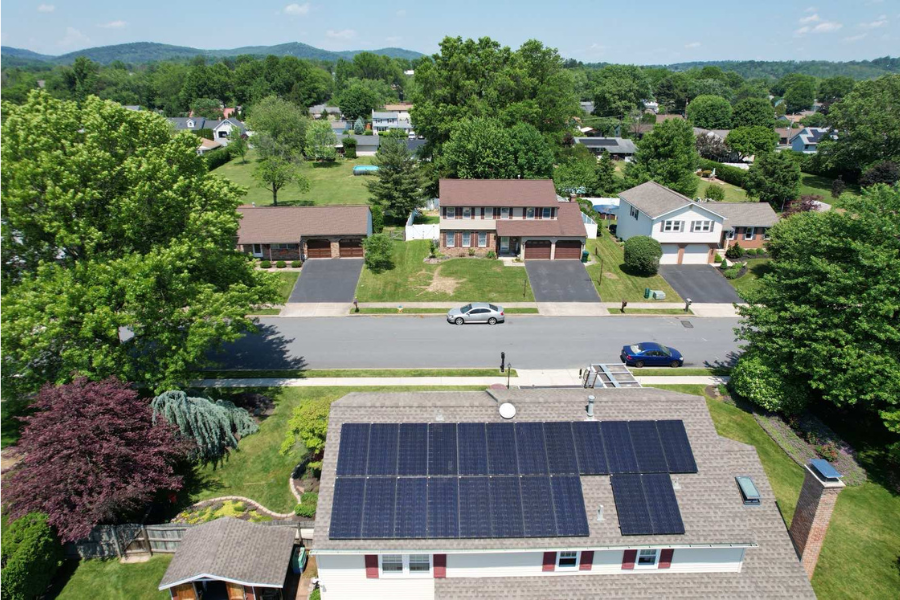 aerial view of home with black solar panels on it