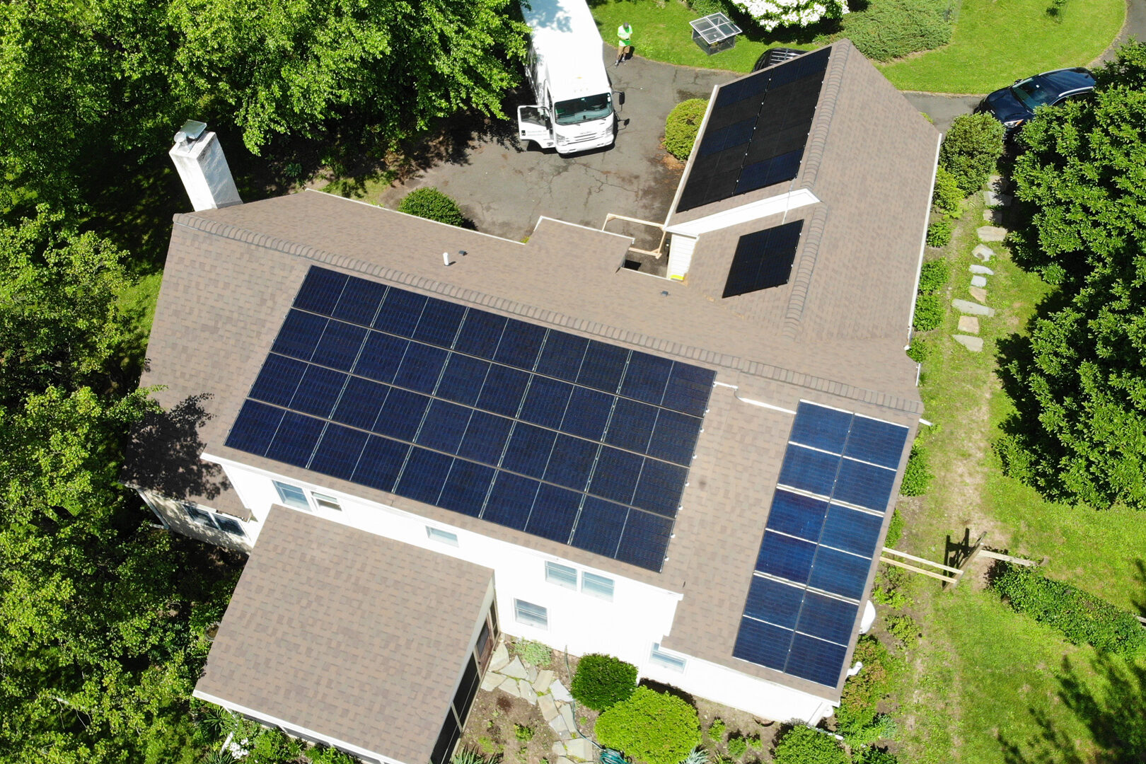 aerial view of black panels being added to large shingle roof