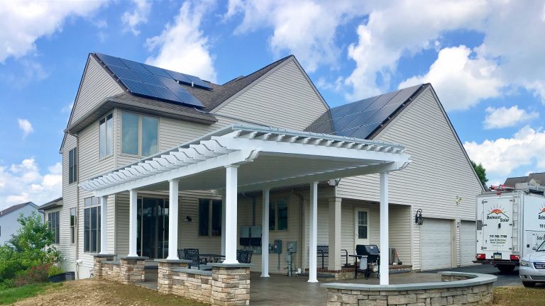 home with pergola in pa featuring solar panels on the roof