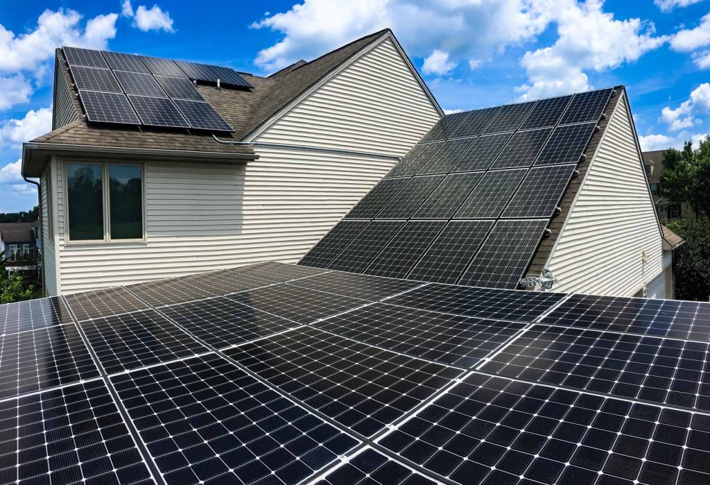 lots of black solar panels on home on sunny and mostly clear day